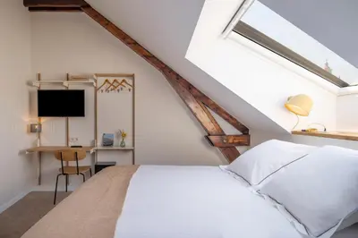 a bedroom with a white bed and a desk at Made in Catherine in Brussels