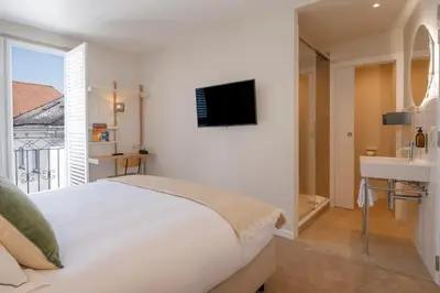 a white bedroom with a bed and a sink at Made in Catherine in Brussels