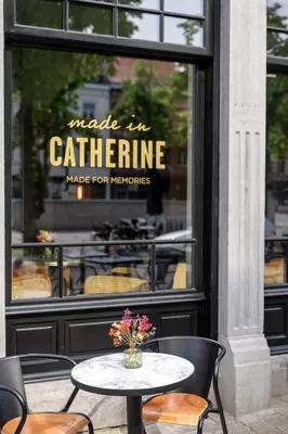 a table and chairs in front of a store window at Made in Catherine in Brussels