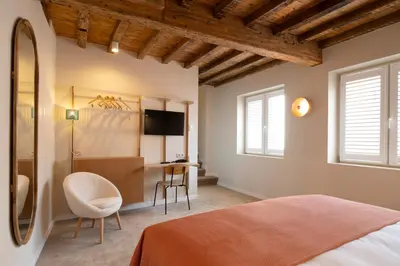 a bedroom with a bed and a desk and a mirror at Made in Catherine in Brussels