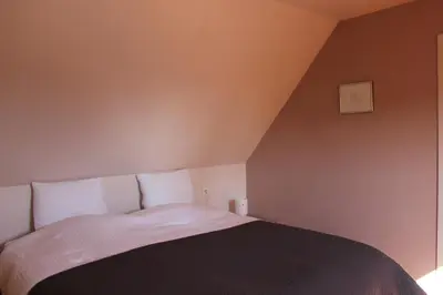a bedroom with a bed with a black and white blanket at De Rosmolen in Ertvelde