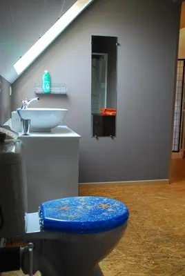 a bathroom with a blue toilet and a sink at De Rosmolen in Ertvelde