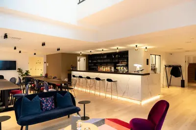 a living room with a bar and some chairs at Corsendonk Turnova in Turnhout