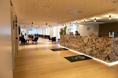 a lobby of a restaurant with a counter and chairs at Corsendonk Turnova in Turnhout