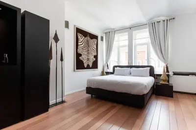 a bedroom with a bed and a large window at Les Lofts d'Artistes in Brussels