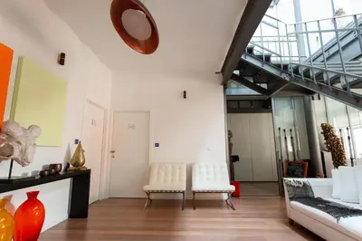 a room with two white chairs and a clock on the wall at Les Lofts d'Artistes in Brussels