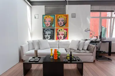a living room with a white couch and a table at Les Lofts d'Artistes in Brussels