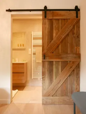 a sliding barn door in a room with a bathroom at De Gulle Beemden in Hulshout
