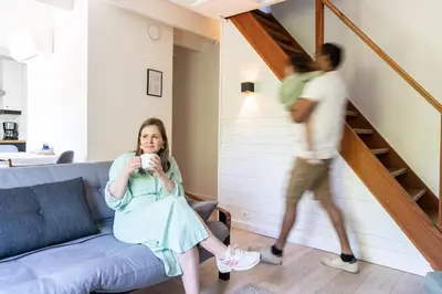a woman sitting on a couch in a living room with a man at De Gulle Beemden in Hulshout
