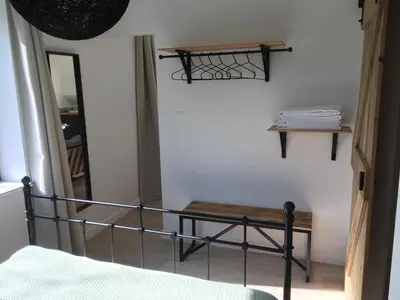 a bedroom with a bed and a bench and a mirror at De Gulle Beemden in Hulshout