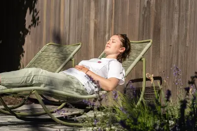 a young man sitting in a lawn chair at De Gulle Beemden in Hulshout