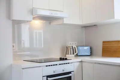 a kitchen with white cabinets and a stove top oven at Luxury Suites Cathedral by Rikas Hotels in Antwerp