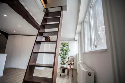 a spiral staircase in a room with a plant at Luxury Suites Cathedral by Rikas Hotels in Antwerp