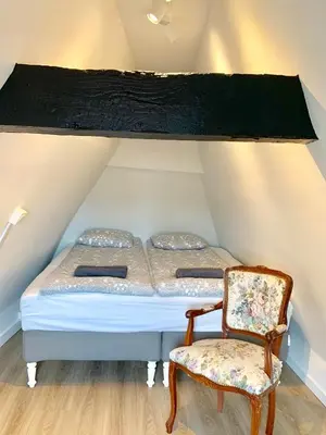 a bed and a chair in a room at Luxury Suites Cathedral by Rikas Hotels in Antwerp
