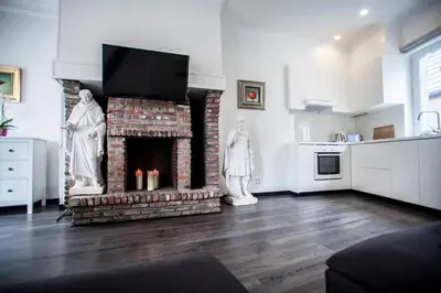 a living room with a brick fireplace with a tv at Luxury Suites Cathedral by Rikas Hotels in Antwerp