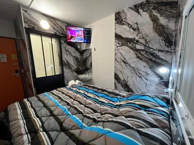 a bedroom with a bed with a tv on the wall at ClassEco Gent in Ghent
