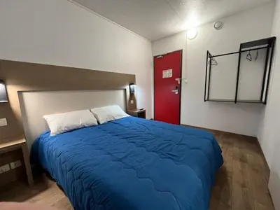 a bedroom with a blue bed and a red door at ClassEco Gent in Ghent