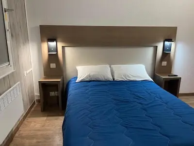 a bedroom with a blue bed with two night stands at ClassEco Gent in Ghent