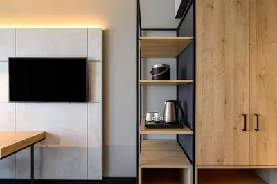 a kitchen with wooden cabinets and a tv in a room at Radisson Hotel Antwerp Berchem in Antwerp