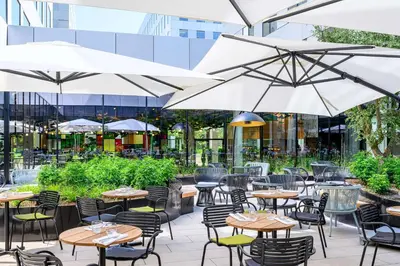 an outdoor patio with tables and chairs and umbrellas at Radisson Hotel Antwerp Berchem in Antwerp