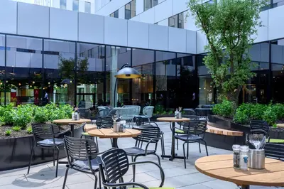 a patio with tables and chairs in front of a building at Radisson Hotel Antwerp Berchem in Antwerp