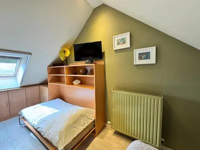 a small bedroom with a bed and a tv at B&B Carpe Diem in Westerlo