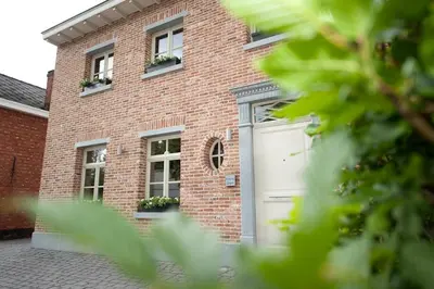 a brick building with a garage and two windows at B&B Carpe Diem in Westerlo