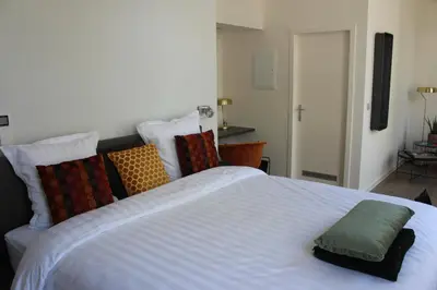 a large white bed with colorful pillows on it at CITYSTAY in Antwerp
