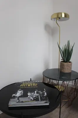 a black coffee table with a book and a lamp at CITYSTAY in Antwerp