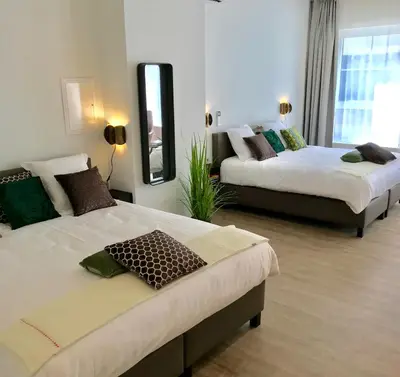 a hotel room with two beds and a mirror at CITYSTAY in Antwerp