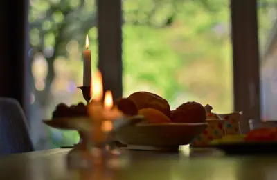 a candle and a plate of fruit on a table at Beeltjens B&B: Wolf&Belle in Westerlo
