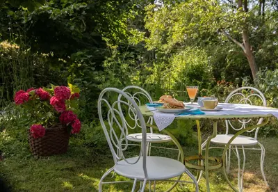 a table with chairs and a plate of food on it at Beeltjens B&B: Wolf&Belle in Westerlo