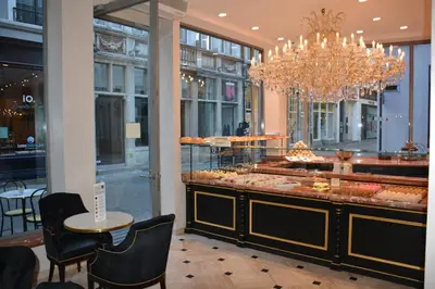 a restaurant with a chandelier and a table and chairs at Merveilleux in Ghent