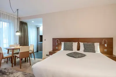 a hotel room with a large bed and a table at Aparthotel Residence Agenda in Brussels