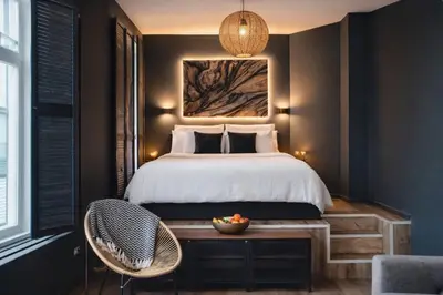 a bedroom with a bed and a bowl of fruit on a wooden table at Noir Loft with Skyline View in Antwerp