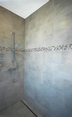 a bathroom with a shower with a shower head at Noir Loft with Skyline View in Antwerp