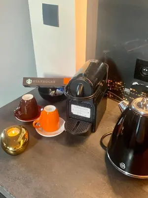 a kitchen counter with a coffee maker and cups at Noir Loft with Skyline View in Antwerp