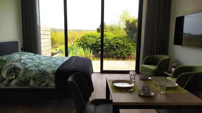 a room with a table and a bed and a table and chairs at B&B Plattestien in Halle