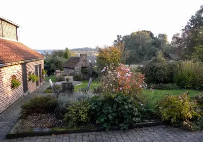 a garden with a table and chairs and a building at B&B Plattestien in Halle