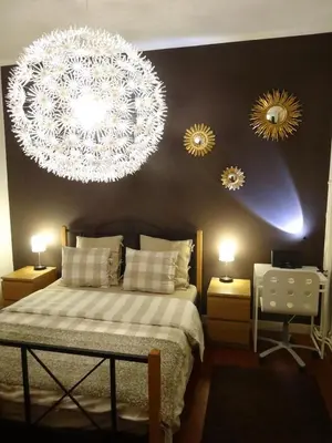a bedroom with a bed with a chandelier and two mirrors at B&B Welcome To My Place in Brussels