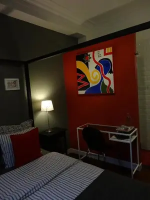 a bedroom with a bed and a desk and a painting at B&B Welcome To My Place in Brussels