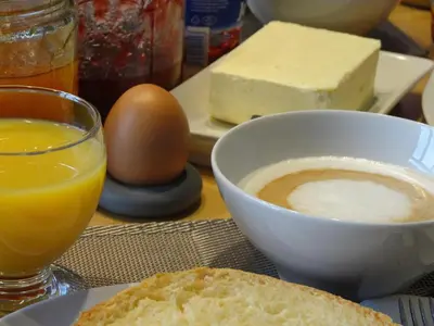 a table with a bowl of coffee and a bowl of cheese at B&B Welcome To My Place in Brussels