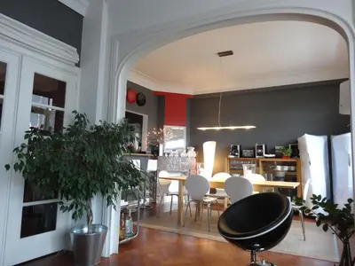 a dining room with a table and white chairs at B&B Welcome To My Place in Brussels