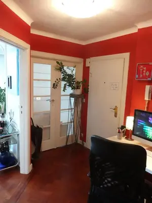 a living room with red walls and a tv and a door at B&B Welcome To My Place in Brussels