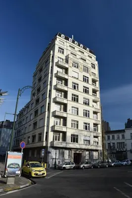 a tall white building with cars parked in front of it at B&B Welcome To My Place in Brussels