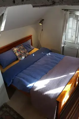 a bedroom with a bed with blue sheets and a window at Studio Rempart in Brussels
