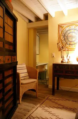 a room with a chair and a table and a mirror at Studio Rempart in Brussels