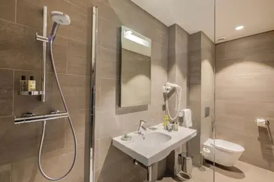 a bathroom with a shower and a sink and a toilet at Le Côté Vert in Waterloo