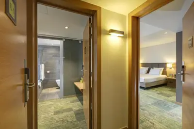 a door leading to a bedroom with a bed at Le Côté Vert in Waterloo
