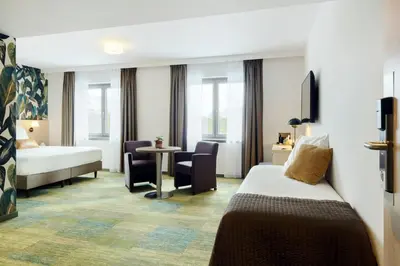 a hotel room with a bed and a table at Le Côté Vert in Waterloo